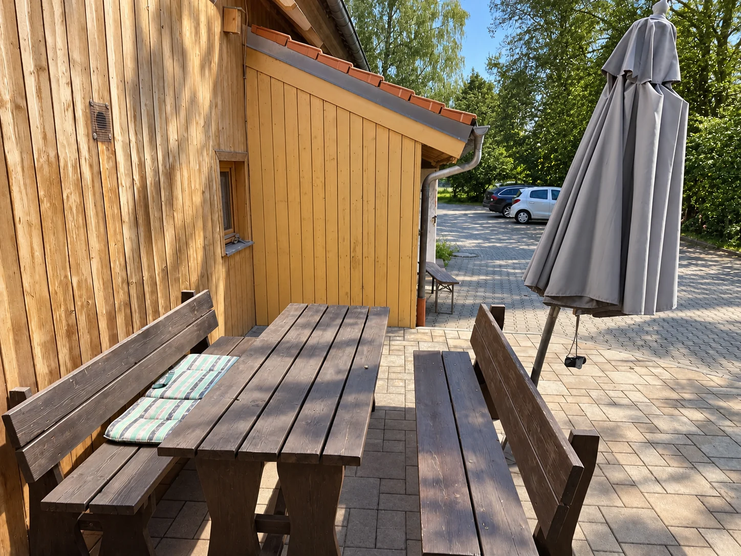 Sitzplatz mit Holztisch und Bänken am Stall