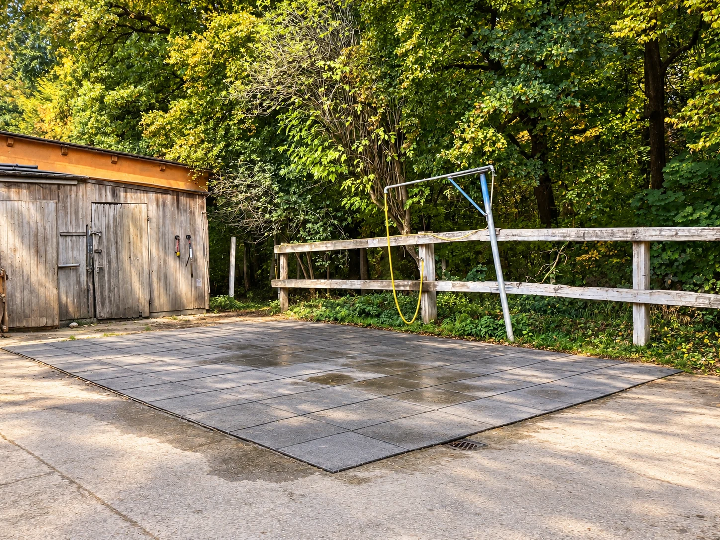 Außenwaschplatz mit Schlauch und Holzzaun
